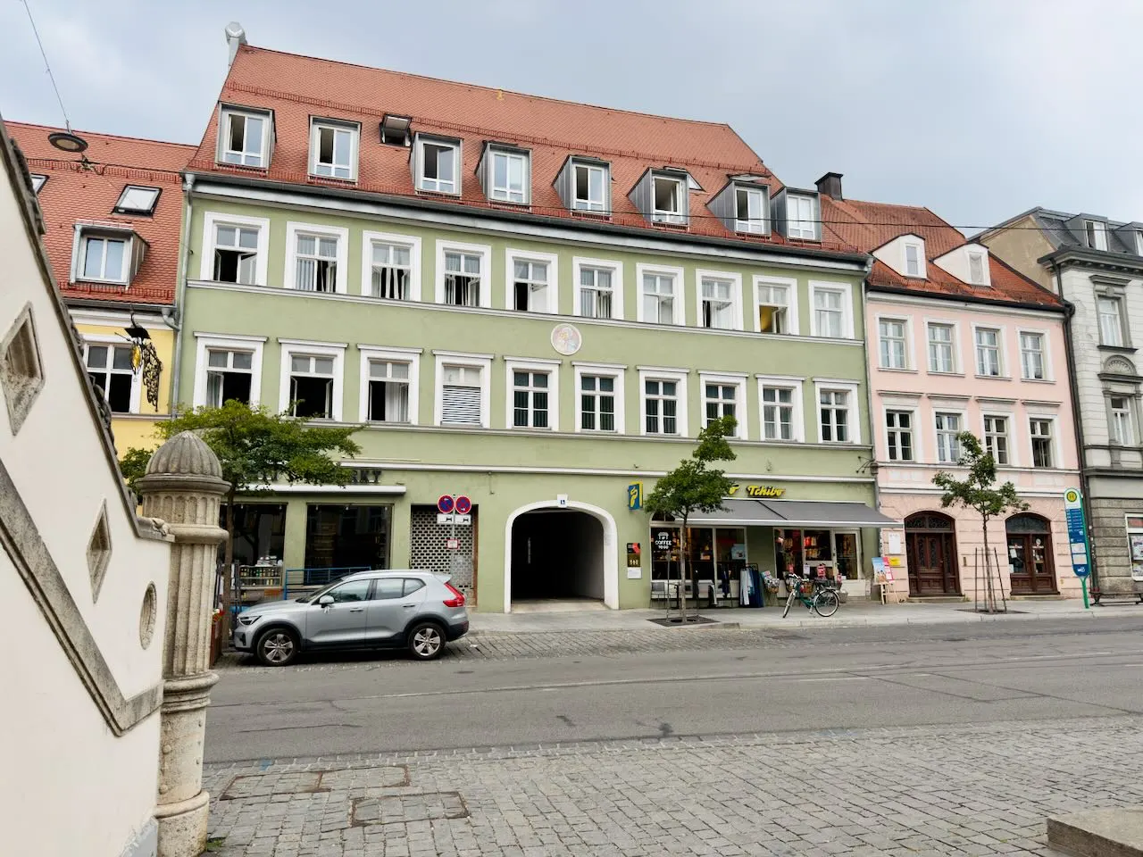 Historic townhouse with a green facade and red tiled roof at Hauptstraße 1A in Fürstenfeldbruck, home of the nuonic office